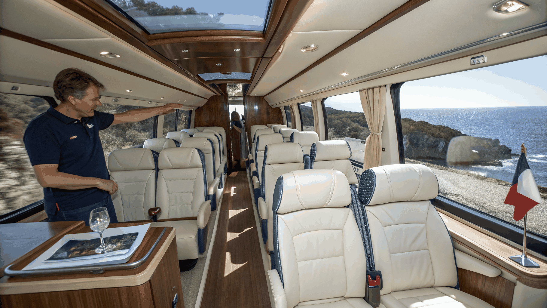 Tour bus interior lounge illuminated by amber ambient lamps during midnight drive